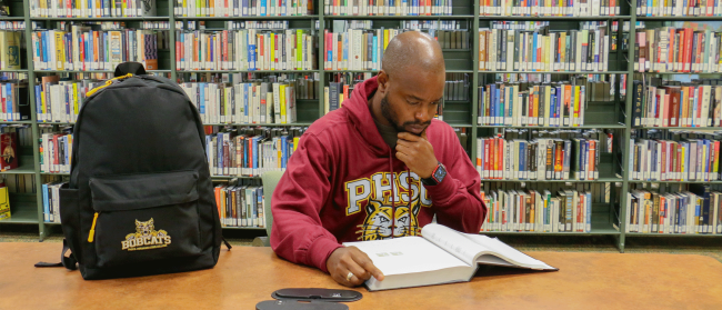 A male PHSC student studying in the library